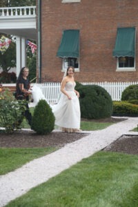 Wedding planner assisting bride, walking together at wedding venue before ceremony.