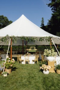 Elegant wedding reception tent set on the garden grounds of Evergreen Museum & Library surrounded by historic estate beauty.